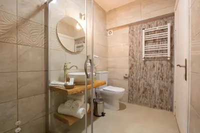 a bathroom with a shower and a toilet and a sink at Aya Butik Otel in Buyukada