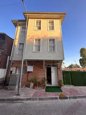 a yellow house with a white door on a street at Lovely History in Istanbul