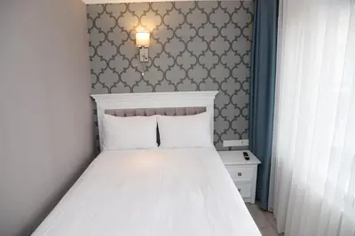 a bedroom with a white bed and a wall at Novus Hotel İstanbul in Istanbul