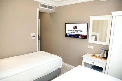 a small room with a bed and a tv on the wall at Novus Hotel İstanbul in Istanbul