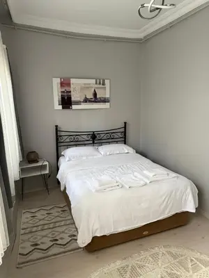 a bedroom with a large bed with white sheets at Güneş House in Istanbul