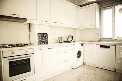 a kitchen with white cabinets and a washer and dryer at Doğanın Kalbindeki Eviniz-9 Kişi in Gemlik