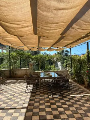 a table and chairs under an umbrella on a patio at Doğanın Kalbindeki Eviniz-9 Kişi in Gemlik