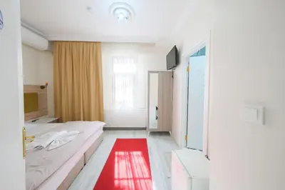 a bedroom with a bed and a red rug at Halil Bey Konağı in Istanbul