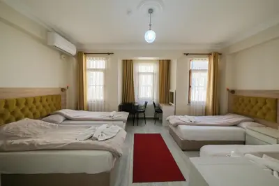 a room with three beds and a red rug at Halil Bey Konağı in Istanbul