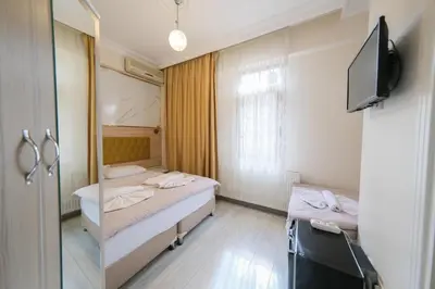 a room with two beds and a tv and a mirror at Halil Bey Konağı in Istanbul