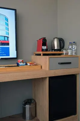 a wooden table with a television on top of it at Brand Business Hotel in Corlu