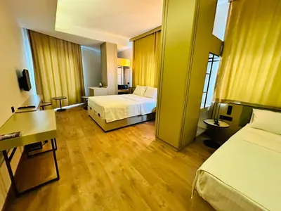 a hotel room with two beds and a desk at Nice Royal Cıty in Istanbul