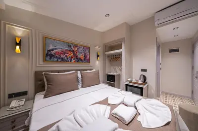 a bedroom with a large bed with white sheets at Pera Luna Premium Hotel in Istanbul