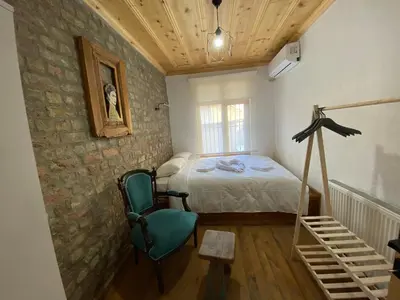 a bedroom with a bed and a green chair at Balat Historical House in Istanbul