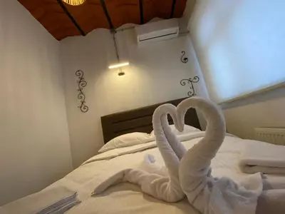 two towel swans making a heart on a bed at Balat Historical House in Istanbul