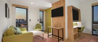 a living room with a tv and a couch and a table at Hampton By Hilton Cerkezkoy in Tekirdag