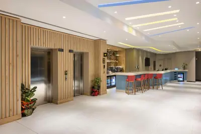 a lobby with a bar with red stools in it at Hampton By Hilton Cerkezkoy in Tekirdag