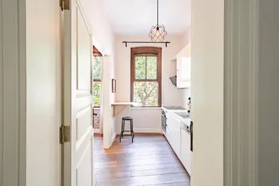 a kitchen with white cabinets and a wooden floor at Homie Suites - Historical Apartment Nearby Galata Tower in Istanbul