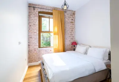 a white bed in a room with a brick wall at Homie Suites - Historical Apartment Nearby Galata Tower in Istanbul