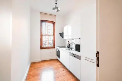 a kitchen with white cabinets and a wooden floor at Homie Suites - Historical Apartment Nearby Galata Tower in Istanbul