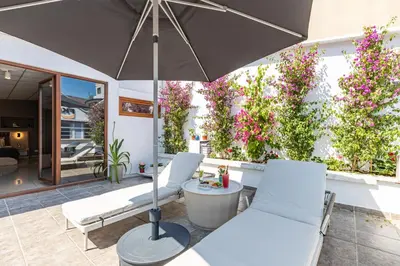 a patio with two white chairs and an umbrella at Bdino Boutique Hotel in Istanbul