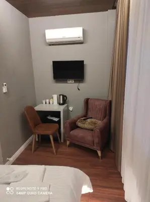 a living room with a chair and a television at TAKSİM GOKOTTA SUiTE in Istanbul