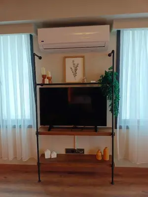 a flat screen tv on a stand in front of two windows at Karaköy in Karaköy Hotel in Istanbul