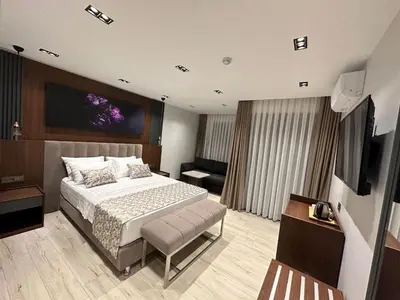 a bedroom with a bed and a television in it at La Miel Şile in Sile