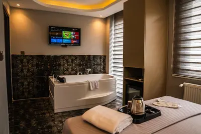 a bathroom with a tub and a tv on the wall at CK PALACE Hotel in Istanbul