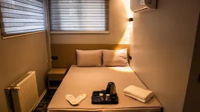 a small room with a bed with two slippers on it at CK PALACE Hotel in Istanbul