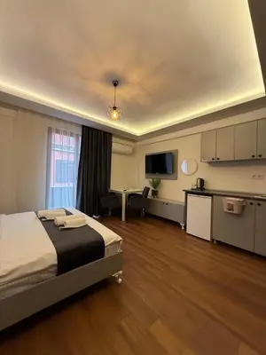 a bedroom with a bed and a desk and a kitchen at Taksim Nova homes in Istanbul
