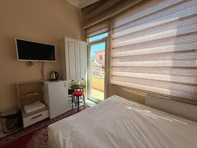 a bedroom with a bed and a window with a television at IQ Hotel in Istanbul