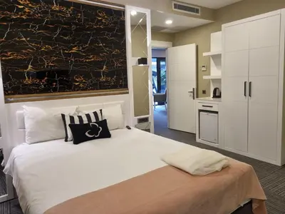 a bedroom with a large white bed and a kitchen at Mia Berre Hotels in Istanbul
