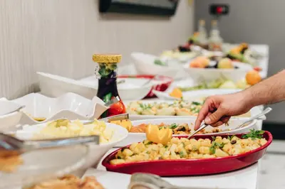 a table filled with plates of food and a person preparing food at Mia Berre Hotels in Istanbul