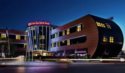 a building at night with its lights on at Hilton Garden Inn Kocaeli Sekerpinar in Şekerpınarı