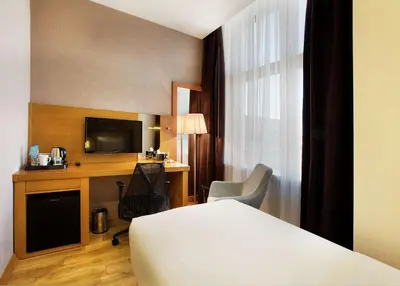 a hotel room with a bed and a desk and a television at Hilton Garden Inn Kocaeli Sekerpinar in Şekerpınarı