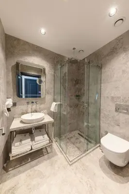 a bathroom with a shower and a toilet and a sink at AHG Atlas Hotel Taksim in Istanbul