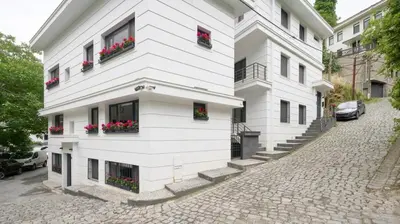 a white building with flowers in the windows at Private Modern 2BR1Bath Bebek Gem! #80 in Istanbul