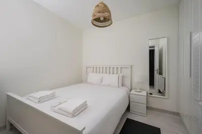 a white bedroom with a white bed and a mirror at Private Modern 2BR1Bath Bebek Gem! #80 in Istanbul