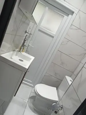 a white bathroom with a toilet and a sink at CEM Apart in Istanbul