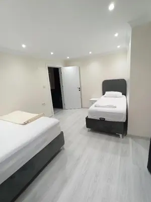 a room with two beds and a hallway with two doors at CEM Apart in Istanbul