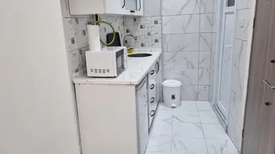 a white bathroom with a sink and a microwave at CEM Apart in Istanbul