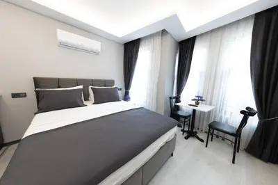 a bedroom with a large bed and a desk at Aya Langa Guest House in Istanbul