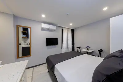 a bedroom with a white bed and a television at Aya Langa Guest House in Istanbul