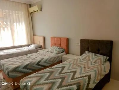 a bedroom with two beds and a couch and a window at Orbital Travel House 1 in Istanbul