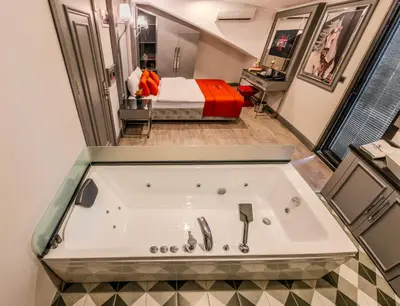 a large bath tub in a room with a bed at Atar Airport Hotel - Restaurant & Spa Wellness in Arnavutköy