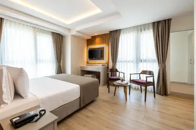a hotel room with a bed and a desk at Carina Gold Hotel And Restaurant in Istanbul