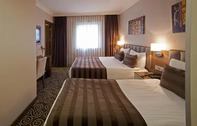 a hotel room with two beds and a window at Delta Hotel Istanbul & Old City in Istanbul