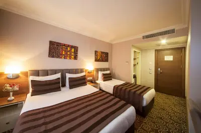 a hotel room with two beds and a door at Delta Hotel Istanbul & Old City in Istanbul
