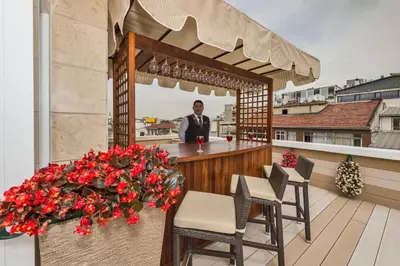a man standing at a bar on a balcony at Darkmen Hotel 2 in Istanbul
