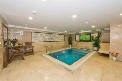 a swimming pool in a room with a tv and a table at Darkmen Hotel 2 in Istanbul