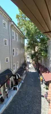 a cobblestone street with umbrellas next to a building at Coskun House in Istanbul