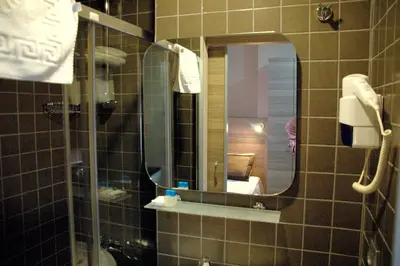 a bathroom with a shower with a mirror and a sink at Sinem Hotel & Old City in Istanbul
