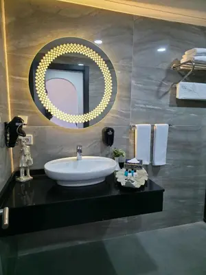 a bathroom with a sink and a round mirror at Gardan Hotel in Beylikduzu